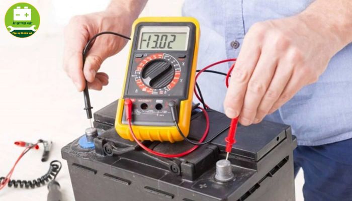 Đặt que đo của đồng hồ vạn năng vào 2 cực của bình acquy