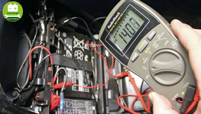 Gắn que đo vào 2 cực của bình ắc quy